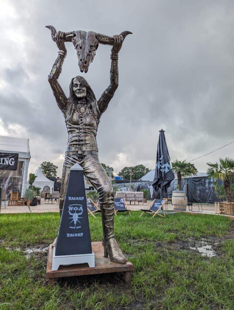 Statue eines Metal-Fans, der einen Totenschädel hochhält, auf dem Wacken Open Air Festival.