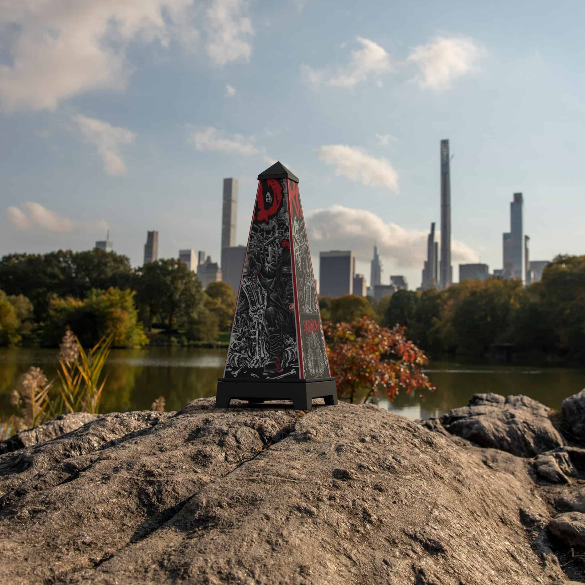 XOUNTS-Soundsystem in Schwarz mit einem Skid Row Monkey Biz StyleCover, das prominent auf einem Stein vor einer Skyline steht