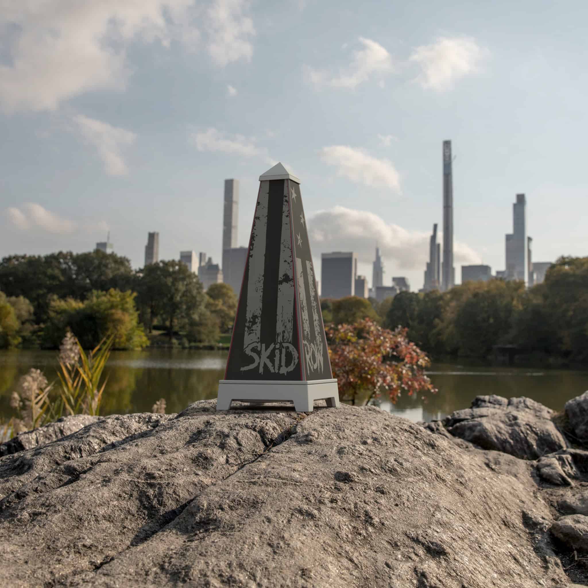 XOUNTS-Soundsystem in Weiß mit einem Skid Row Rebel Flag StyleCover, das prominent auf einem Stein vor einer US Skyline steht