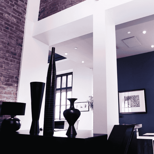 Modernes Loft mit Backsteinwand, minimalistischen Deko-Elementen und offenem Wohnbereich – inspirierendes Interior Design für bessere Raumakustik und perfekte Integration von XOUNTS 360° Sound. Material Mix.